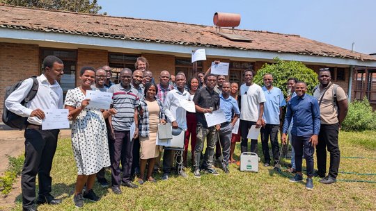 Participants and lecturers from the course in Mangochi The picture shows participants and lecturers from the course in Mangochi standing in front of a building. The participants are holding their certificates.