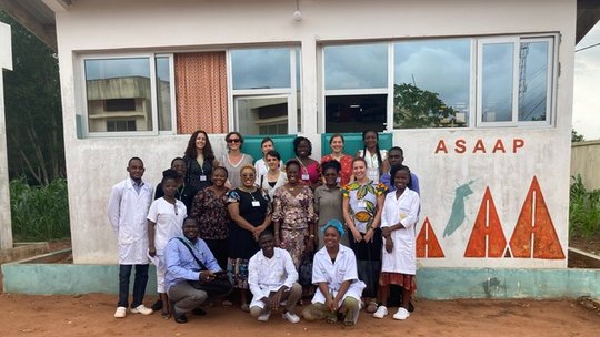 Visiting the ASAAP Benin Team during the Annual Meeting. 20 people in front of a white building of the ASAAP study in Benin