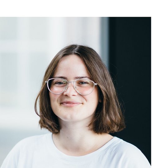 Vivien Barth Portrait of a white female person with glasses and a long brown bob, wearing a white shirt.