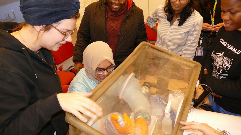 Glove box Demonstration Das Foto zeigt 5 Frauen um eine Glove box.