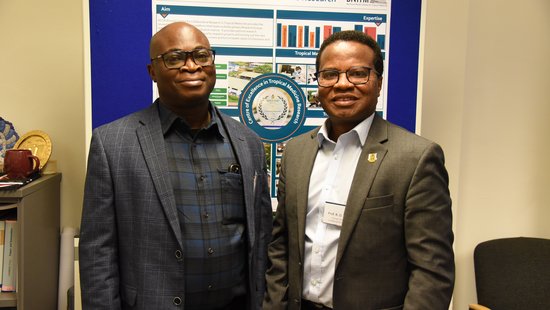 The photo shows two researchers from the KCCR/Ghana in front of a flip chart with a scientific poster.