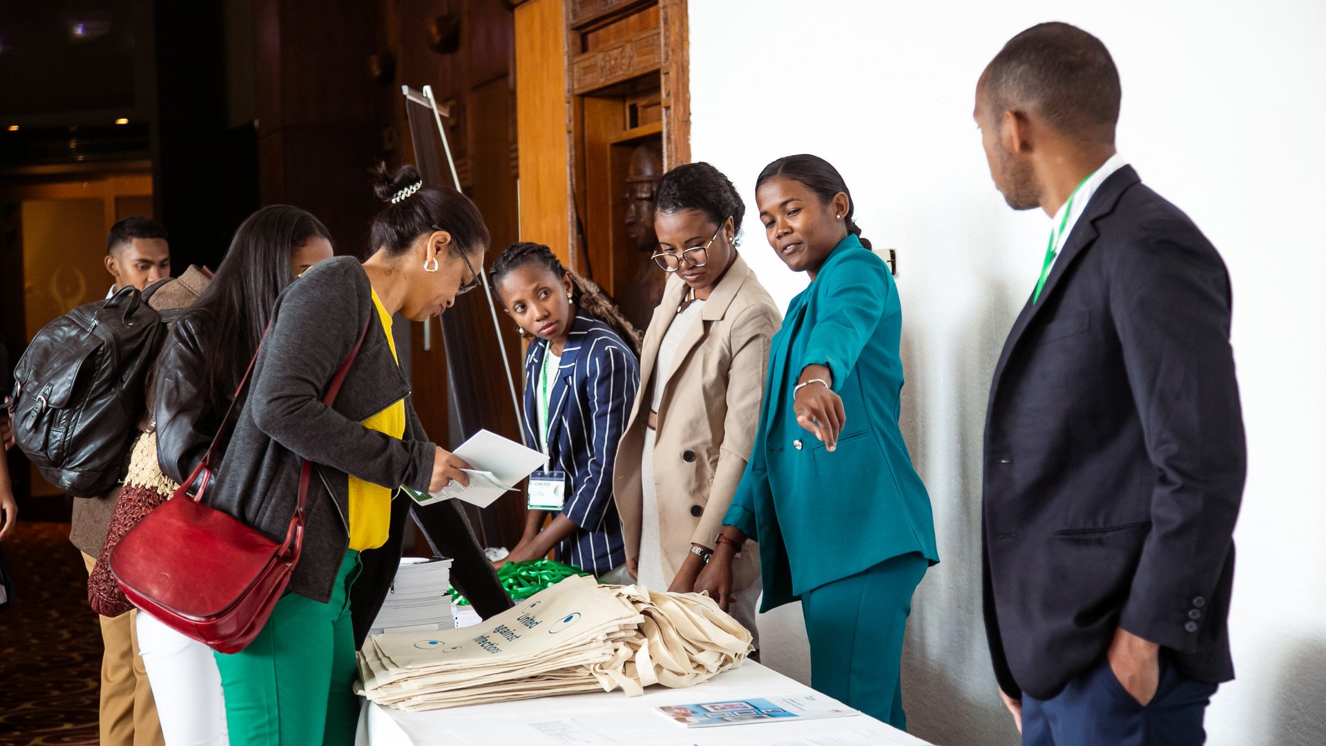 CCSM attendees at a registration table signing documents and interacting with event staff, with others waiting in line in a busy conference environment.