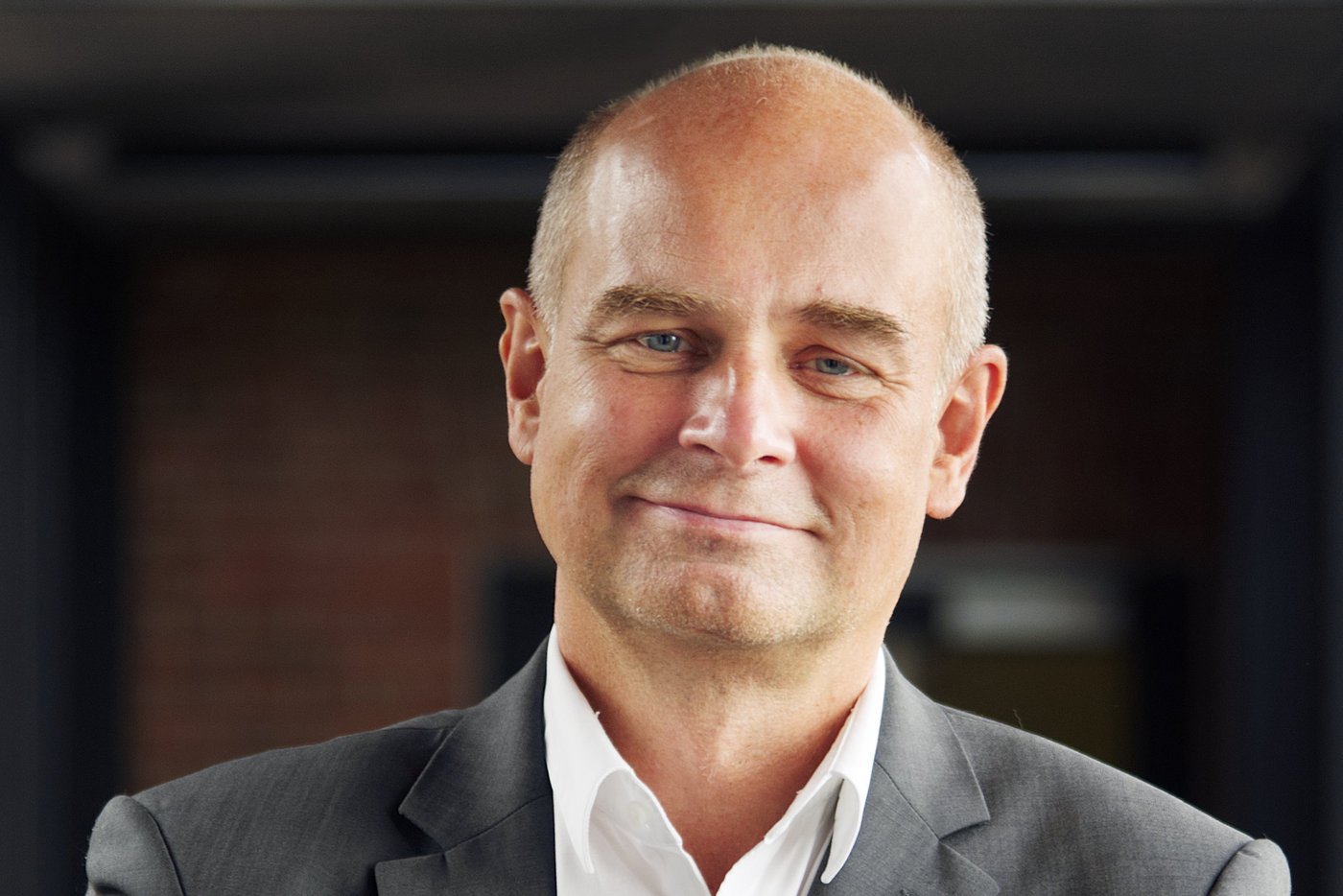 Prof. Jürgen May, Chairman of BNITM Prof. Dr. Jürgen May:a researcher who is bald and wears a white shirt with a gray jacket.