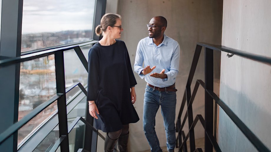 Two friendly people talking while walking on a staircase. Two friendly people talking while walking on a staircase.