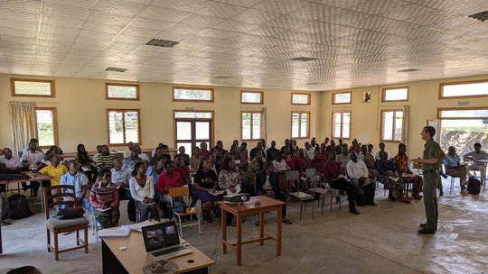 Day 1 training snakebite training of health care workers The picture shows a group of people sitting on chairs. A man is standing in front of the audience.