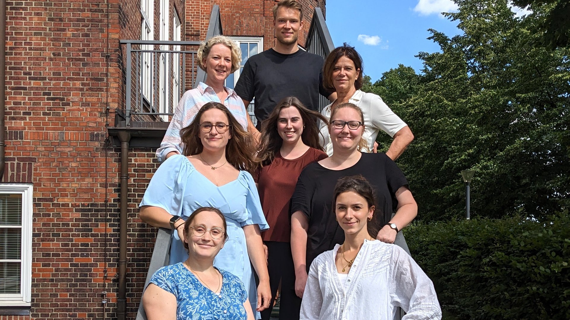 The research group with 8 members ist standig on a scale in the garden of the bernhard-Nocht-Institut. it´s quiet summery.