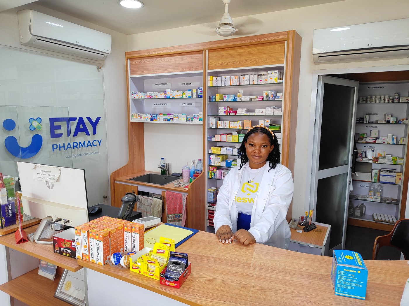 A pharmacist stands behind her counter