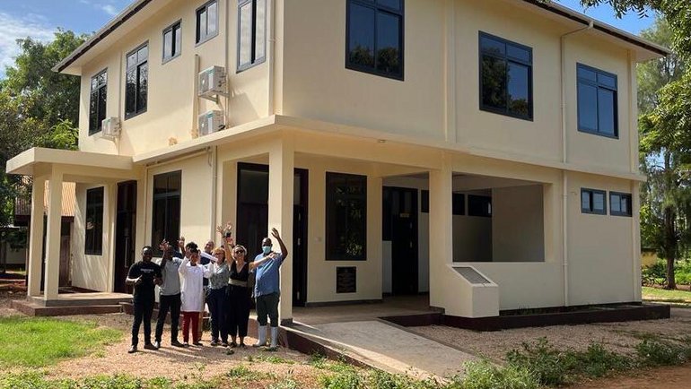 Team Zanzibar, Tanzania, Health Improvement Project Eine Gruppe steht vor einem neu gebauten Haus.