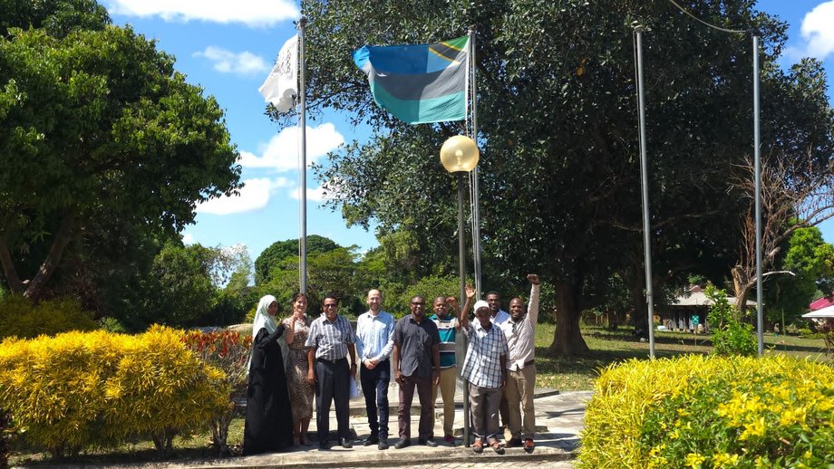 All attendies on the PHL Campus Ein Gruppenfoto auf dem PHL-Campus mit den Leitern aller drei kooperierenden Einrichtungen: Dr. Denise Dekker, Gruppenleiterin von One Health Bacteriology (zweite von links), Dr. Said Mohammed Ali, Geschäftsführer des Public Health Laboratory Ivo de Carneri (PHL-IdC) in Pemba (dritter von links), und Simon Kühnert, Geschäftsführer des Health Improvement Program Zanzibar (HIPZ) (vierter von links).
