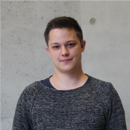 Johannes Allweier Portrait photo of the doctoral student Johannes Allweier in front of a grey concrete wall in the new building of the BNITM.