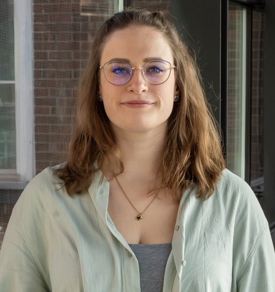 Dr. Charlotte Hansen Portraitfoto der Nachwuchsforscherin Dr. Charlotte Hansen. Sie trägt schulterlange dunkle Haare, eine Brille, eine Halskette und ein hellgrünes Twinset. Sie blickt freundlich in die Kamera.