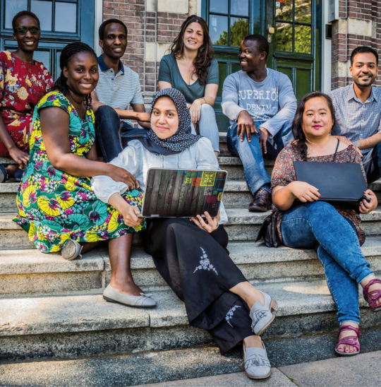 International tropEd Students The picture shows a group of international diverse students sitting outside on a staircase