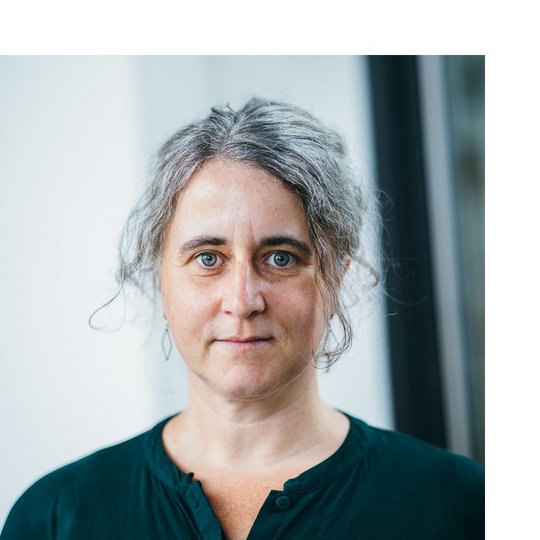 Dr. Nicole Wiederrroth Portrait of a white female person with brown-grey hair pulled back, wearing a dark green shirt