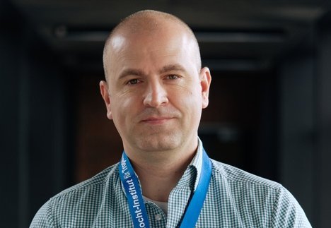 Dr. Dániel Cadar Dr. Dániel Cadar: ein Forscher, der ein blau-weiß kariertes Hemd trägt und eine Glatze hat.