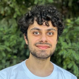 Young researcher looking into the camera on a green backround