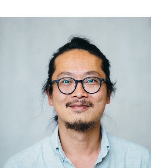 Dr. Sung-Joon Park Portrait of a male person of color with glasses and dark hair pulled back, wearing a blue shirt.