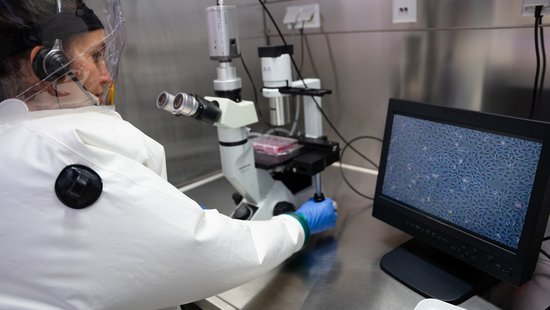 The photo shows a female scientist in a BSL-4-laboratory