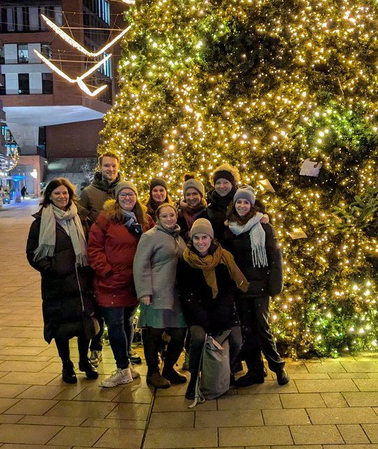 Christmas picture RG Lotter Colleagues from the Lotter research group stand in front of a large Christmas tree with lots of lights in the pedestrian zone of Hamburg's Hafencity