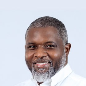 Prof. Dr. John Amuasi PhD John Amuasi: a researcher wearing a suit, dark short hair and a short beard.