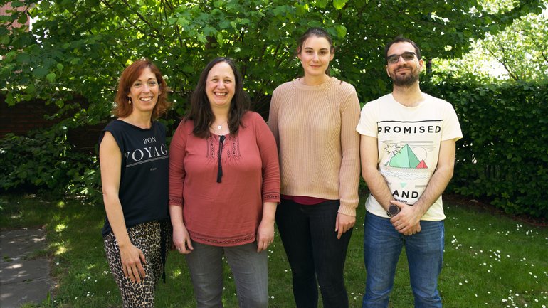 Preclinical Models Research Group Rodríguez Eine Gruppe Forscher im Garten, die in Richtung Bildbetrachter schauen.