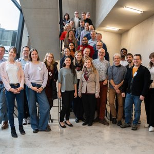 Die Teilnehmenden der Vollversammlung des Leibniz-Forschungsverbunds INFECTIONS stehen für ein Gruppenfoto im Treppenhaus beisammen.