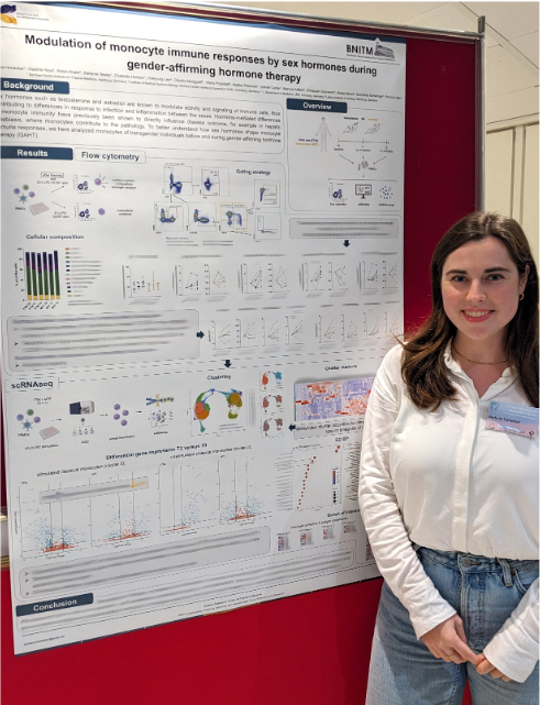 Dr. Barbara Honecker during her poster presentation The picture shows Barbara Honecker giving her poster presentation. She is wearing jeans and a white blouse and smiling warmly at the camera.